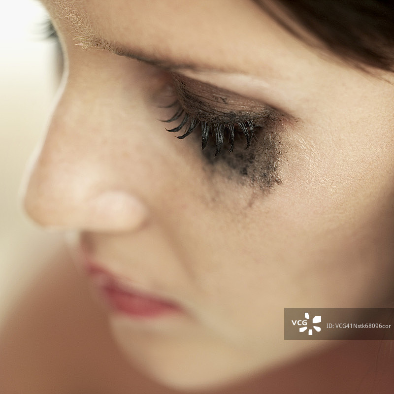 一个女人的脸的特写与睫毛膏涂抹在她的眼睛周围图片素材