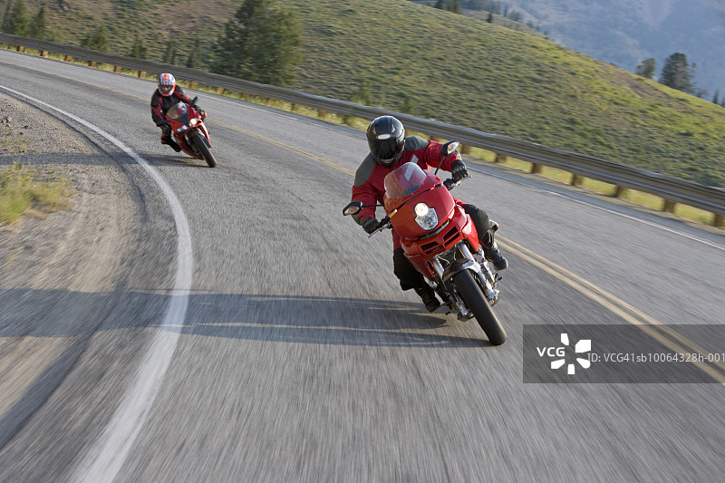 两个男人骑着摩托车在乡间小路上图片素材