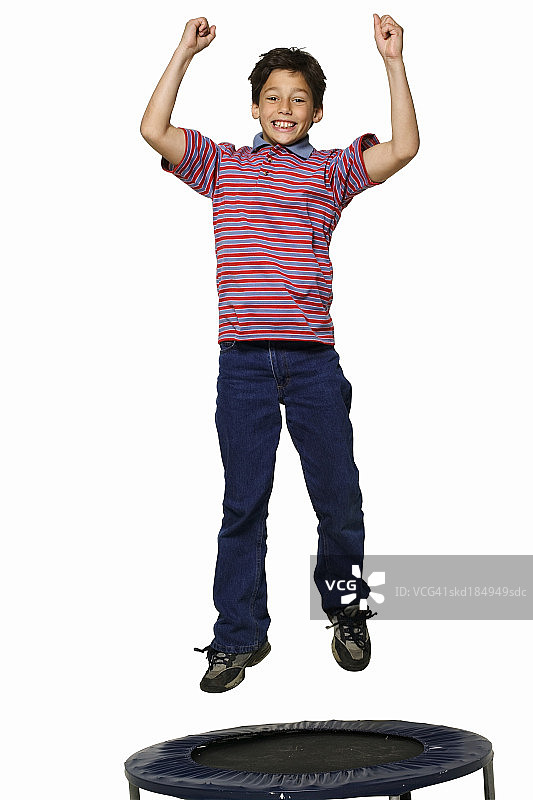 一个男孩(11-12岁)在蹦床上跳图片素材