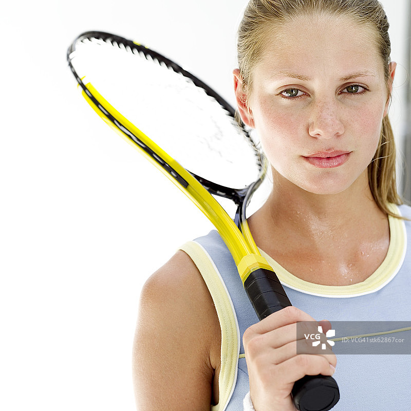 一个年轻女子把网球拍放在肩上的肖像图片素材