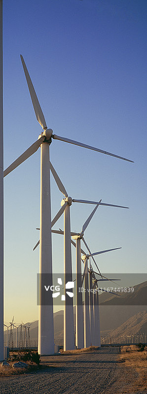 山脉前的一排发电风车图片素材