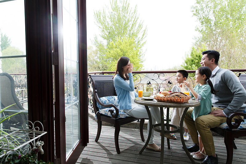 幸福家庭在阳台吃早餐图片下载