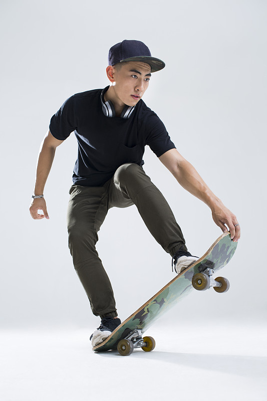 戴耳机的年轻男子在滑滑板图片下载