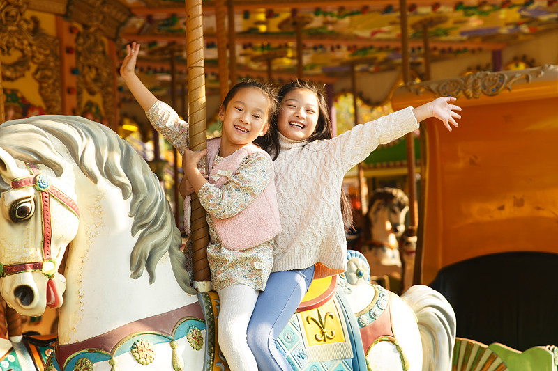 两个小女孩在玩旋转木马图片下载