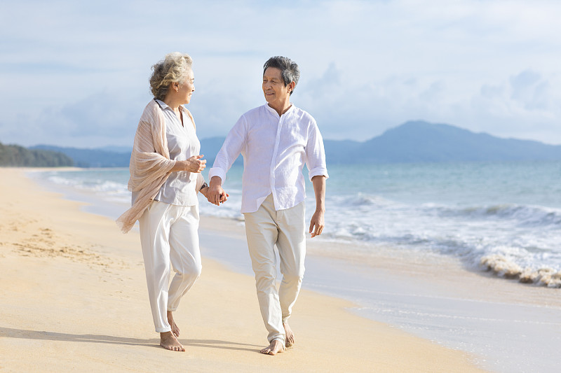快乐的老年夫妇在沙滩散步图片下载