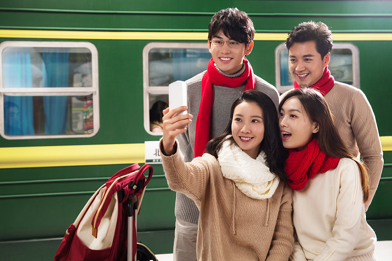 青年男女在火车站台上用手机图片下载