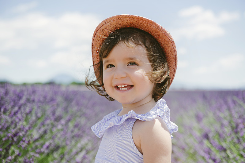 法国，普罗旺斯，瓦朗索高原，快乐的学步女孩在紫色薰衣草的田野在夏天图片下载