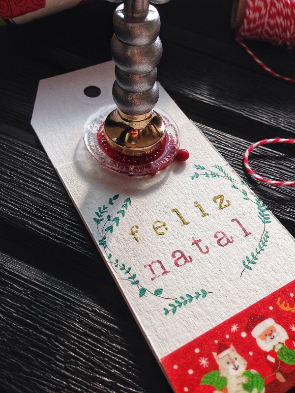 在用葡萄牙语写着“圣诞快乐”的圣诞礼物标签上盖章图片下载
