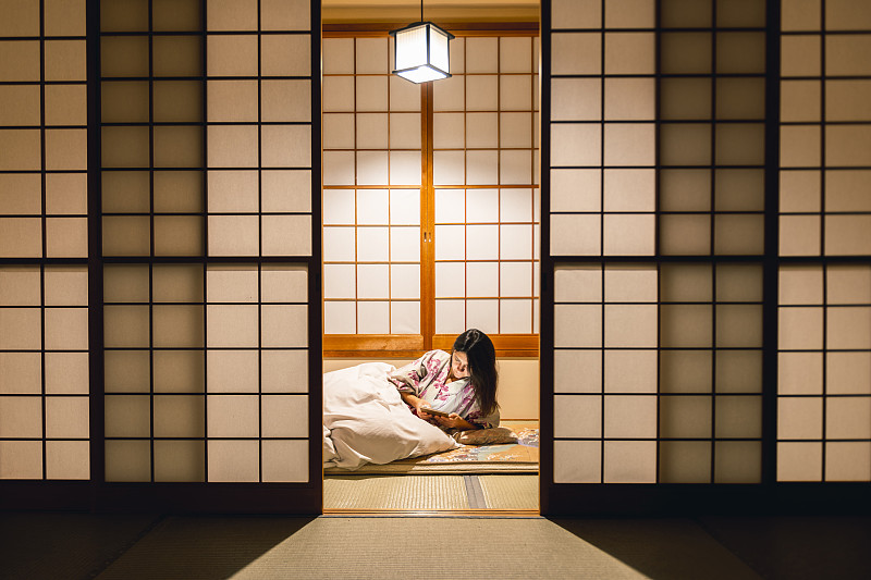 在传统的日式旅馆里用平板电脑工作的女人图片下载