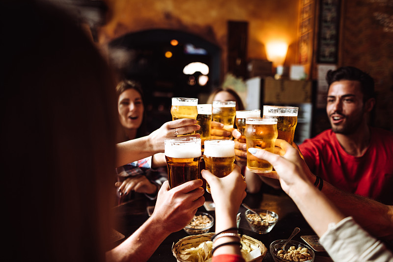 人们在酒吧里喝着啤酒聊天、敬酒图片下载