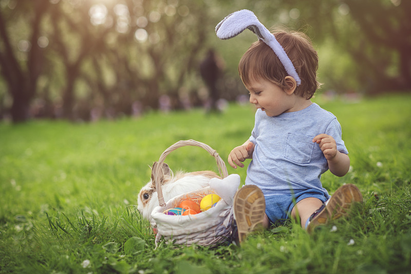 可爱的小男孩玩兔子和复活节彩蛋图片下载