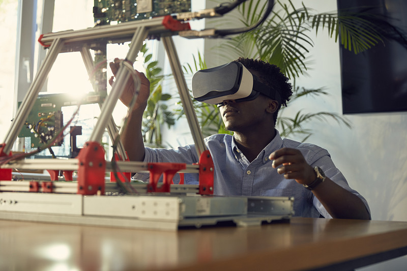 年轻的非洲裔男子使用虚拟现实眼镜。制作设备原型图片素材