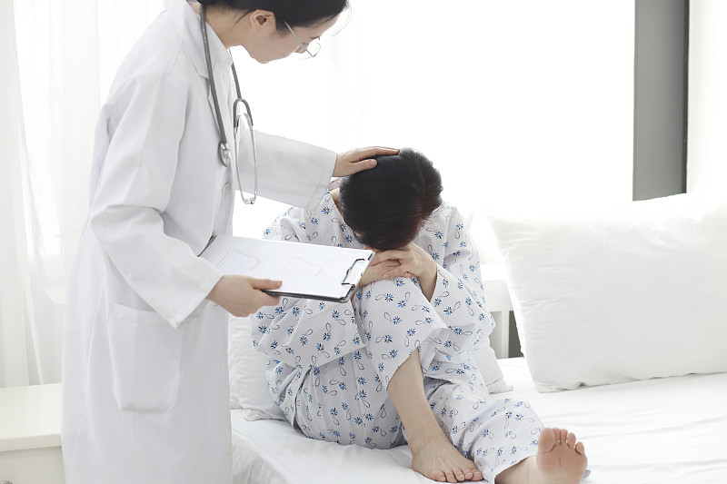 医生在床上检查病人的头痛图片素材