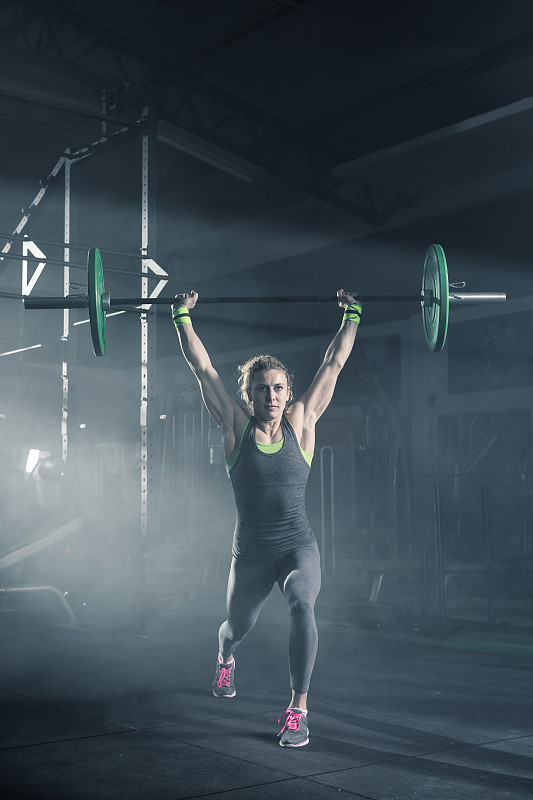 女运动员在健身房做举重锻炼图片下载