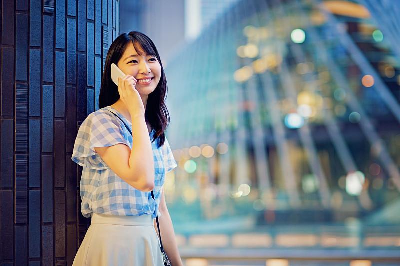 一个年轻的日本女人正在用手机说话图片下载