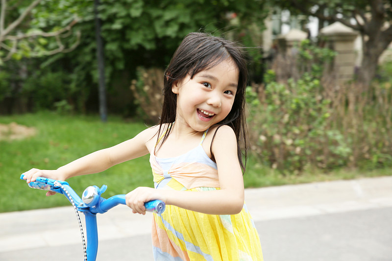 快乐的小女孩骑滑板车图片素材