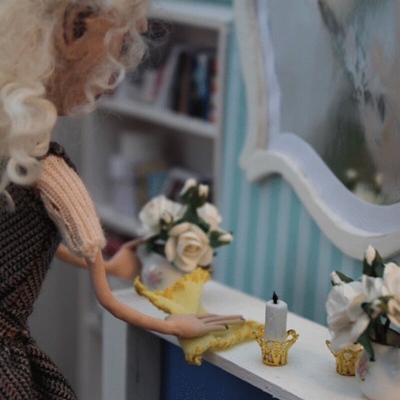 木偶形象的女人清洁桌子花瓶，停止运动效果图片下载