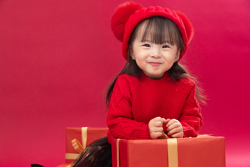 幸福的小女孩趴在礼物包装盒上图片下载
