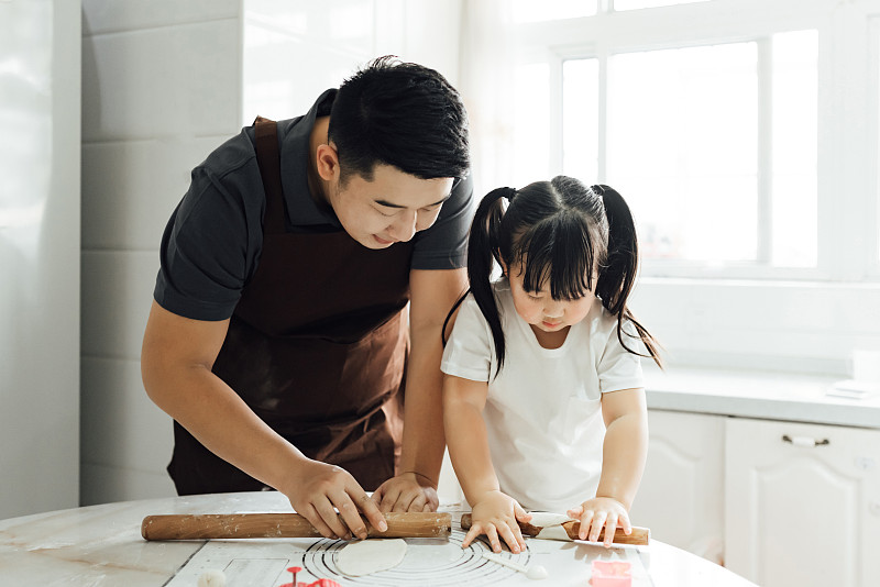 亚洲父女两人正在厨房里做烘焙面包图片素材