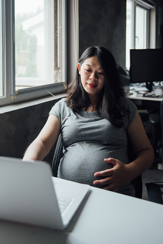 一位亚洲孕妇正在办公图片素材