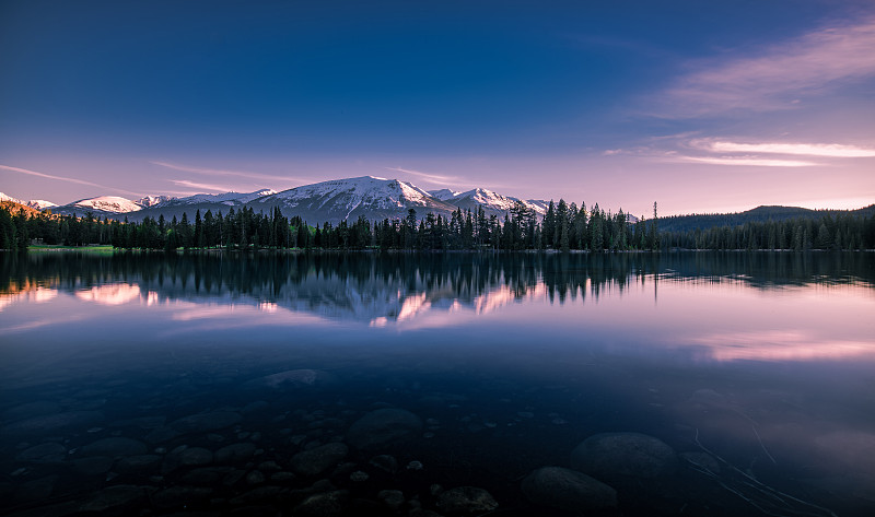 日落时分，白雪皑皑的山峰映衬着湖面的风景图片下载