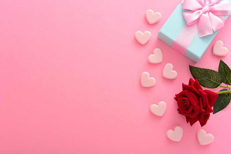情人节粉色背景上的玫瑰花和礼物图片素材