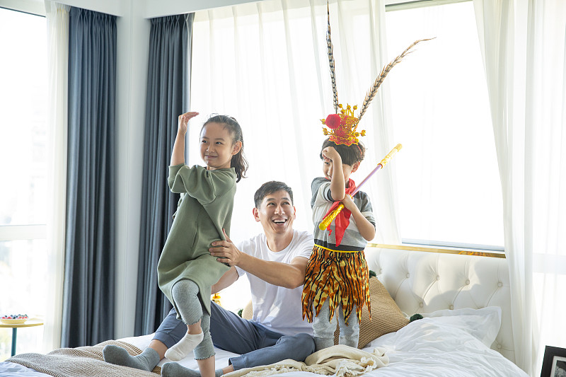 爸爸和两个孩子在卧室玩耍装扮孙悟空图片素材