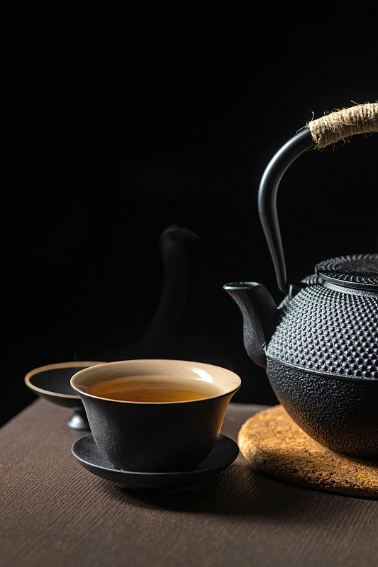 黑陶茶具三才杯盖碗与铁壶摆放在木桌面上深色调图片下载