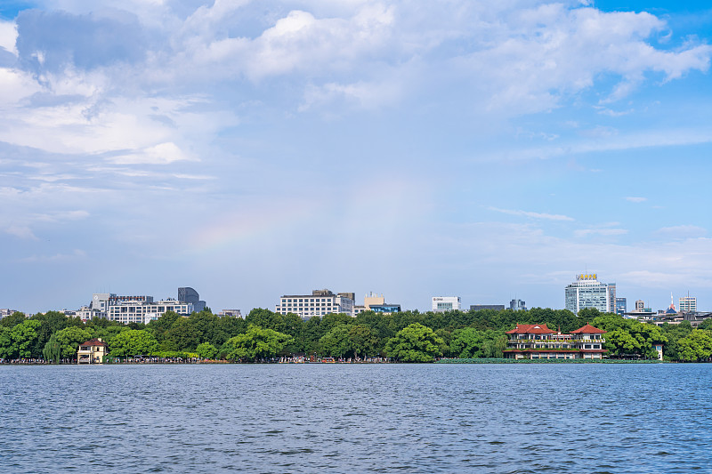 浙江杭州西湖景区夏天雷雨后城市上方的天空中出现彩虹图片下载