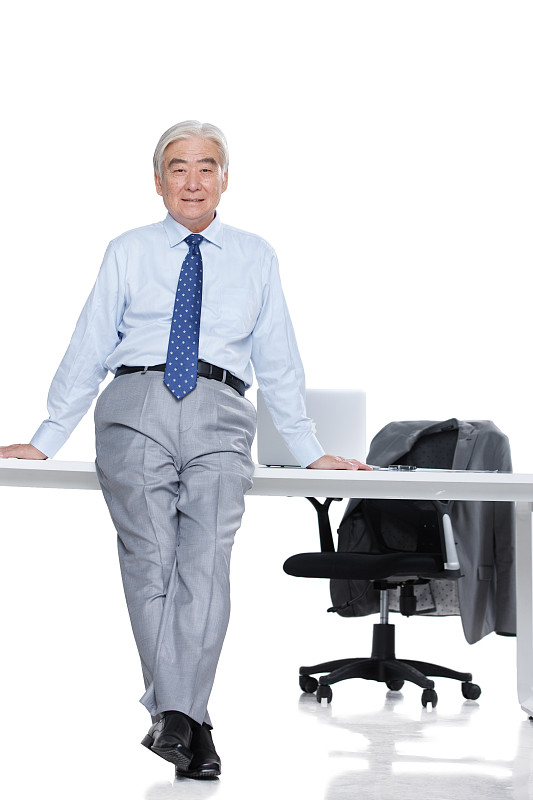成功的老年男人斜靠在办公桌上图片下载