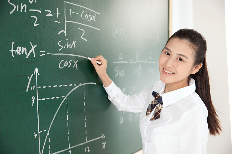 中学女生在黑板前写数学公式图片下载