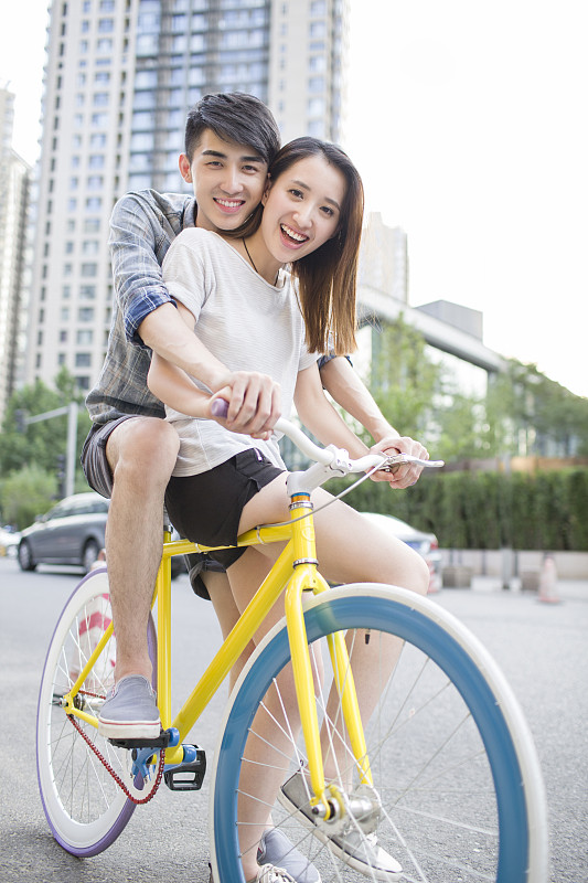 快乐的年轻情侣骑自行车图片下载