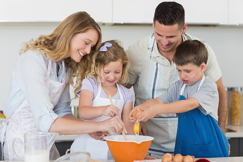 幸福家庭在厨房里拌鸡蛋烤饼干图片下载