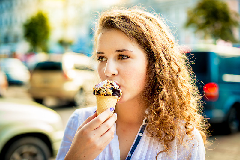 一个女人在吃美味的巧克力冰淇淋图片下载