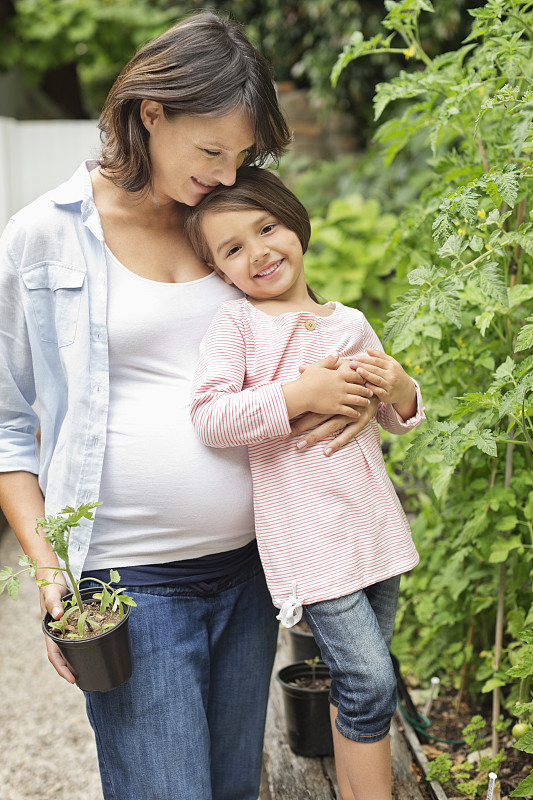 怀孕的母亲和女儿一起园艺图片下载