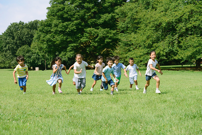 日本孩子在城市公园里跑步图片素材