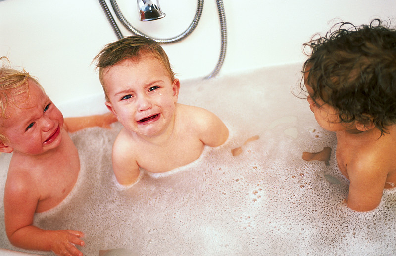 三个蹒跚学步的孩子在浴缸里图片素材