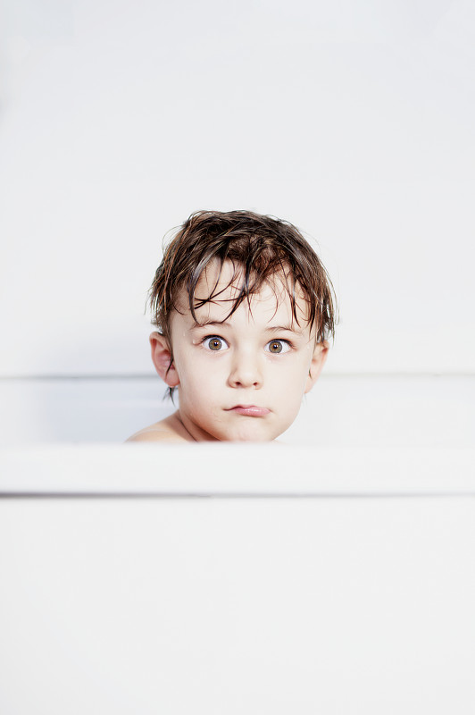 男孩的肖像(8-9)坐在浴缸里图片素材