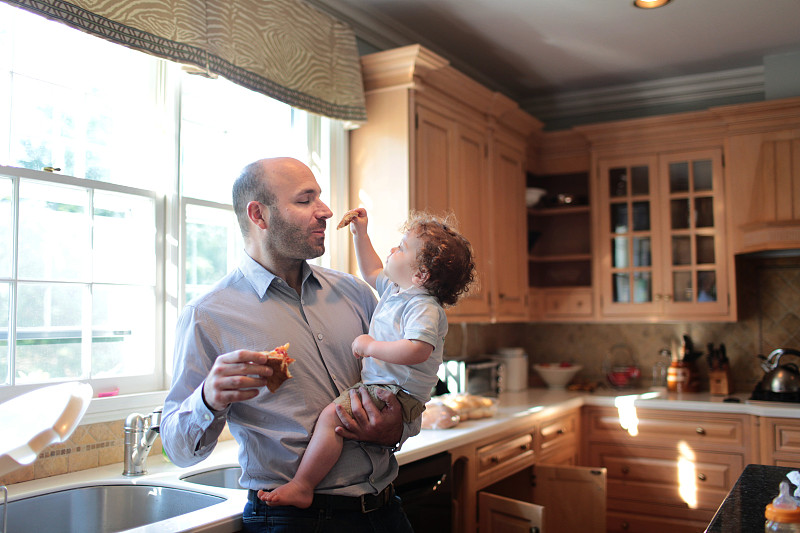 父亲抱着儿子在厨房里图片素材