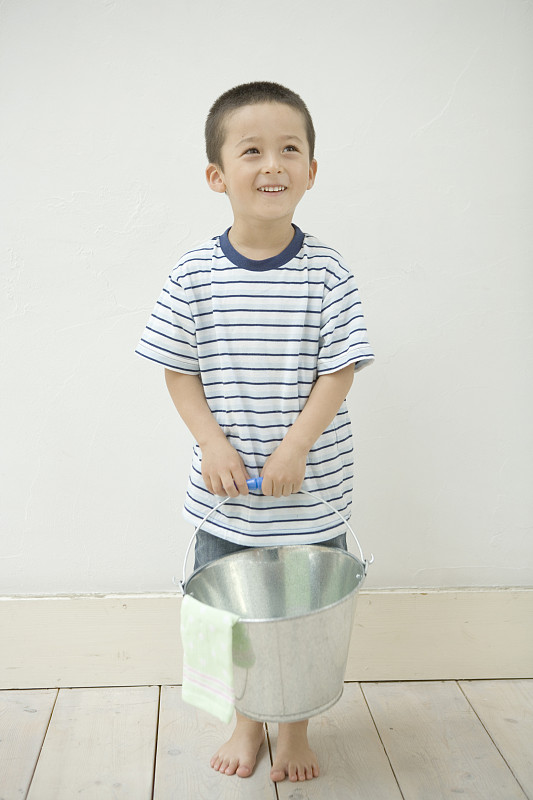 小男孩的肖像，提着水桶，微笑着图片下载
