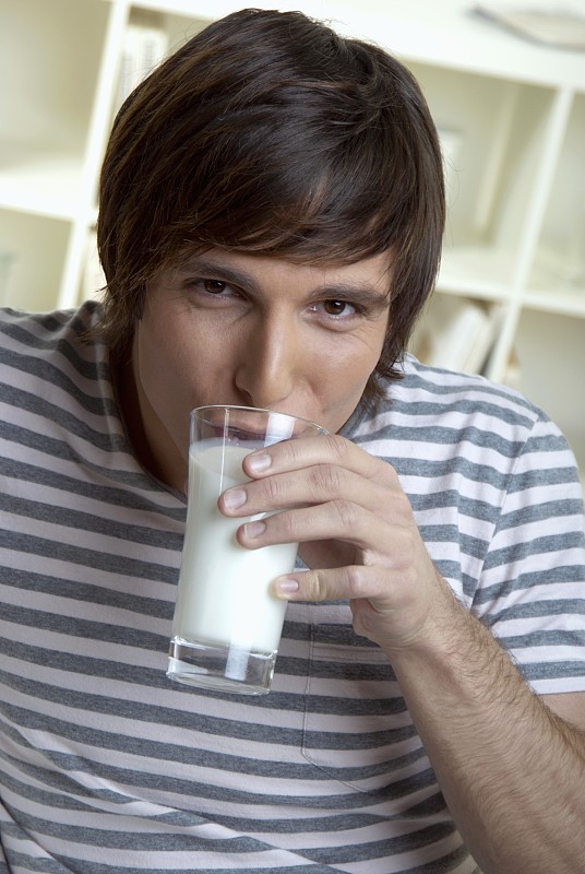 年轻人喝着一杯牛奶图片下载