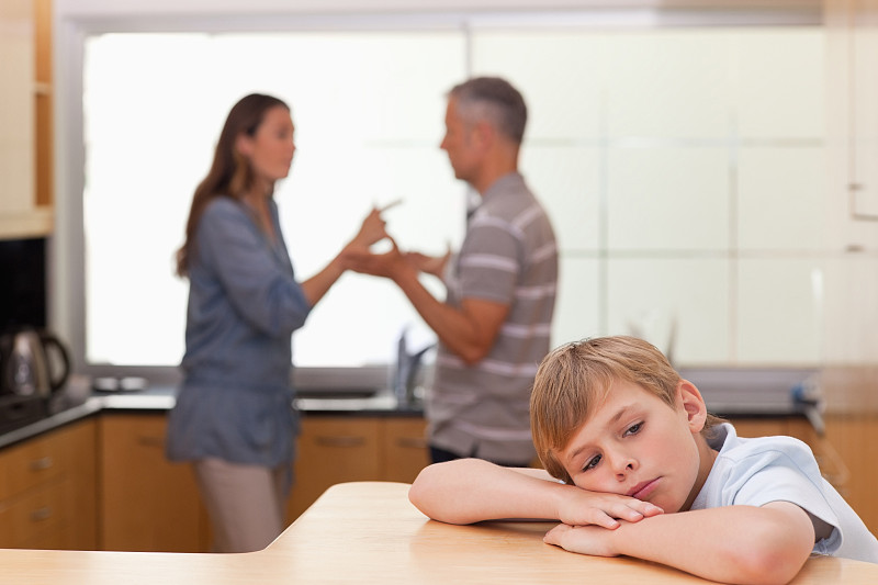 悲伤的小男孩听到他的父母在厨房争吵图片下载