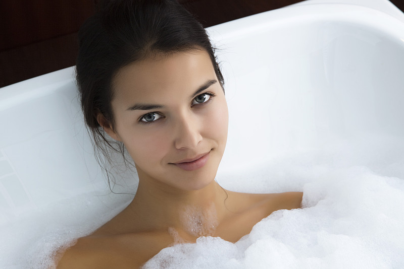 在泡泡浴中放松的女人，肖像图片下载