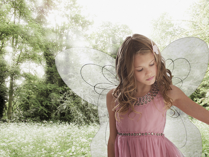 戴着仙女翅膀的女孩在花丛中图片素材