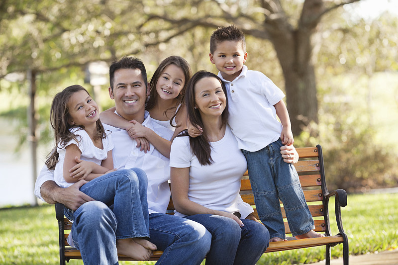 快乐的父母和三个孩子在公园图片下载