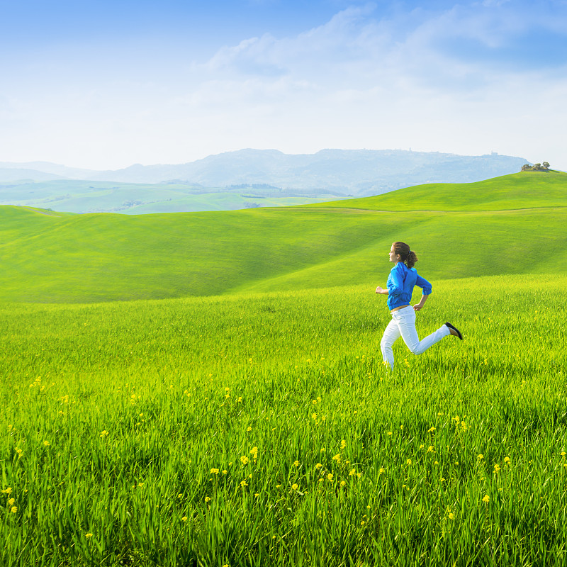 自由:女孩在绿色的田野里奔跑图片下载