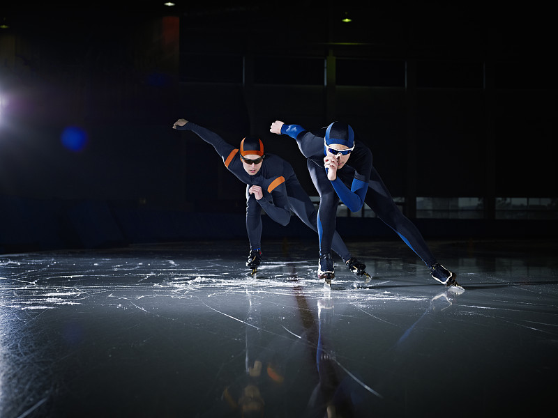 两个长道速滑选手在赛道上比赛图片下载