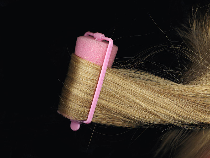 头发卷成粉红色的卷发器图片下载