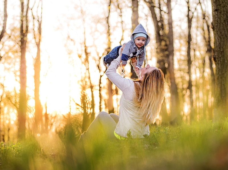 母亲和婴儿在一个春天的日落。图片下载