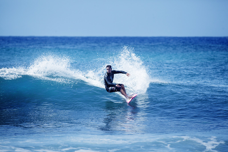 一名男子在夏威夷考艾岛用冲浪板冲浪图片下载